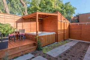 Cabanon en cèdre intégré à la clôture avec un espace couvert pour le spa (projet Daigle)