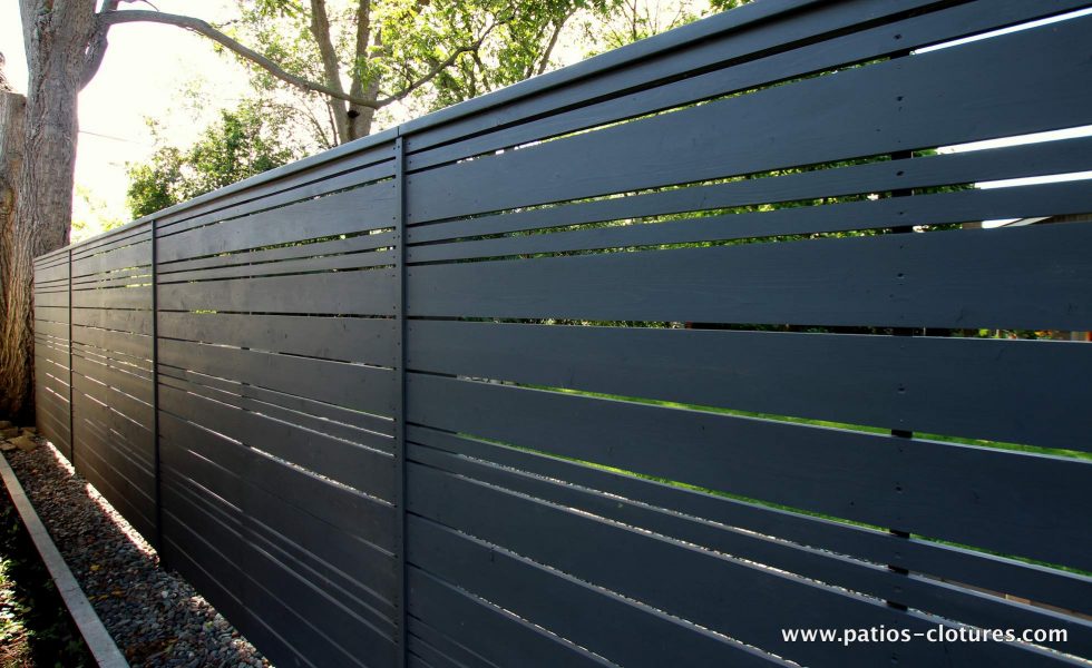 clôture horizontale en bois foncé ajourée avec alternance
